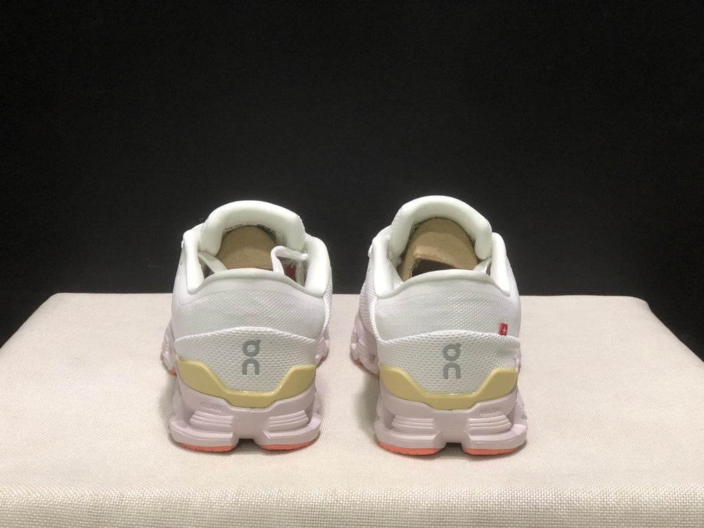 Rear view of the pair showing the On logos, padded collars, and yellow heel details.