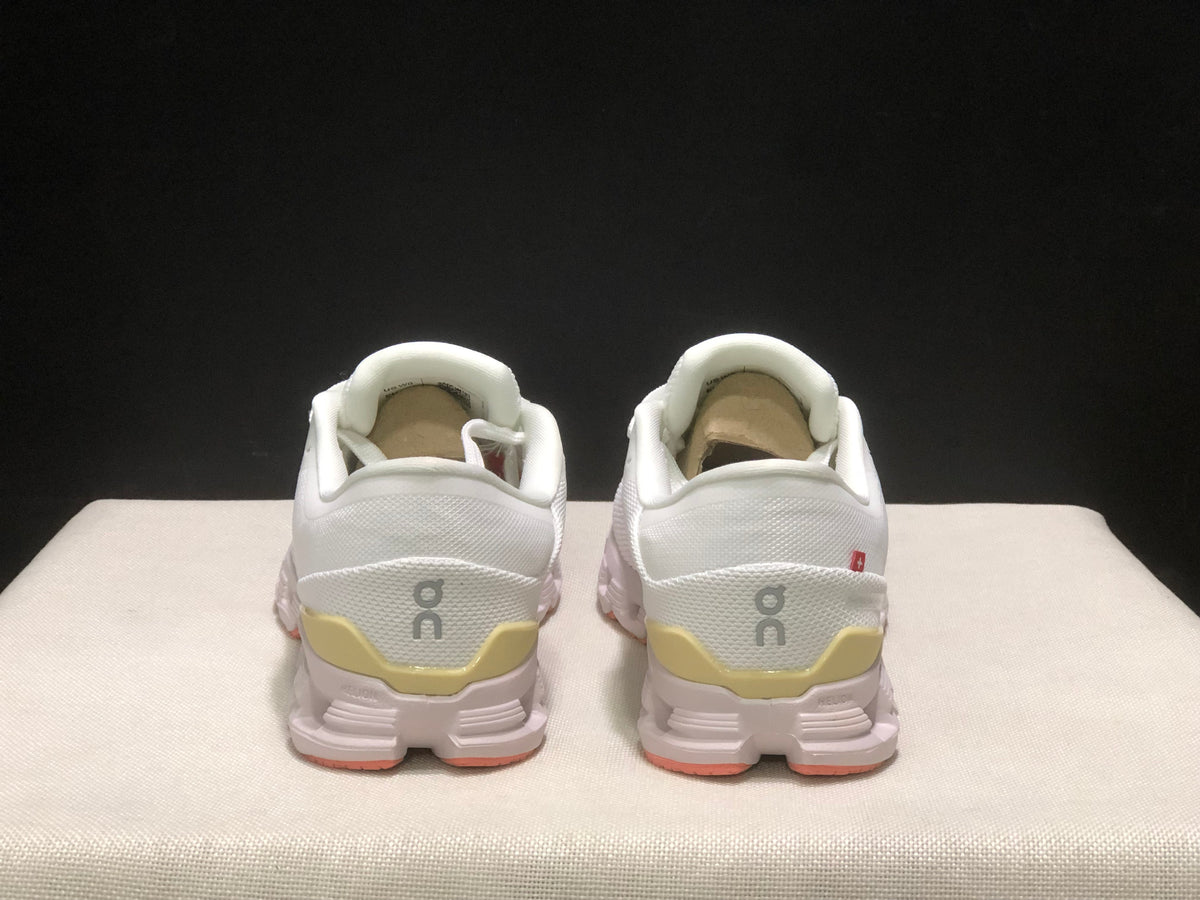 Rear view of the pair showing the On logos, padded collars, and yellow heel details.