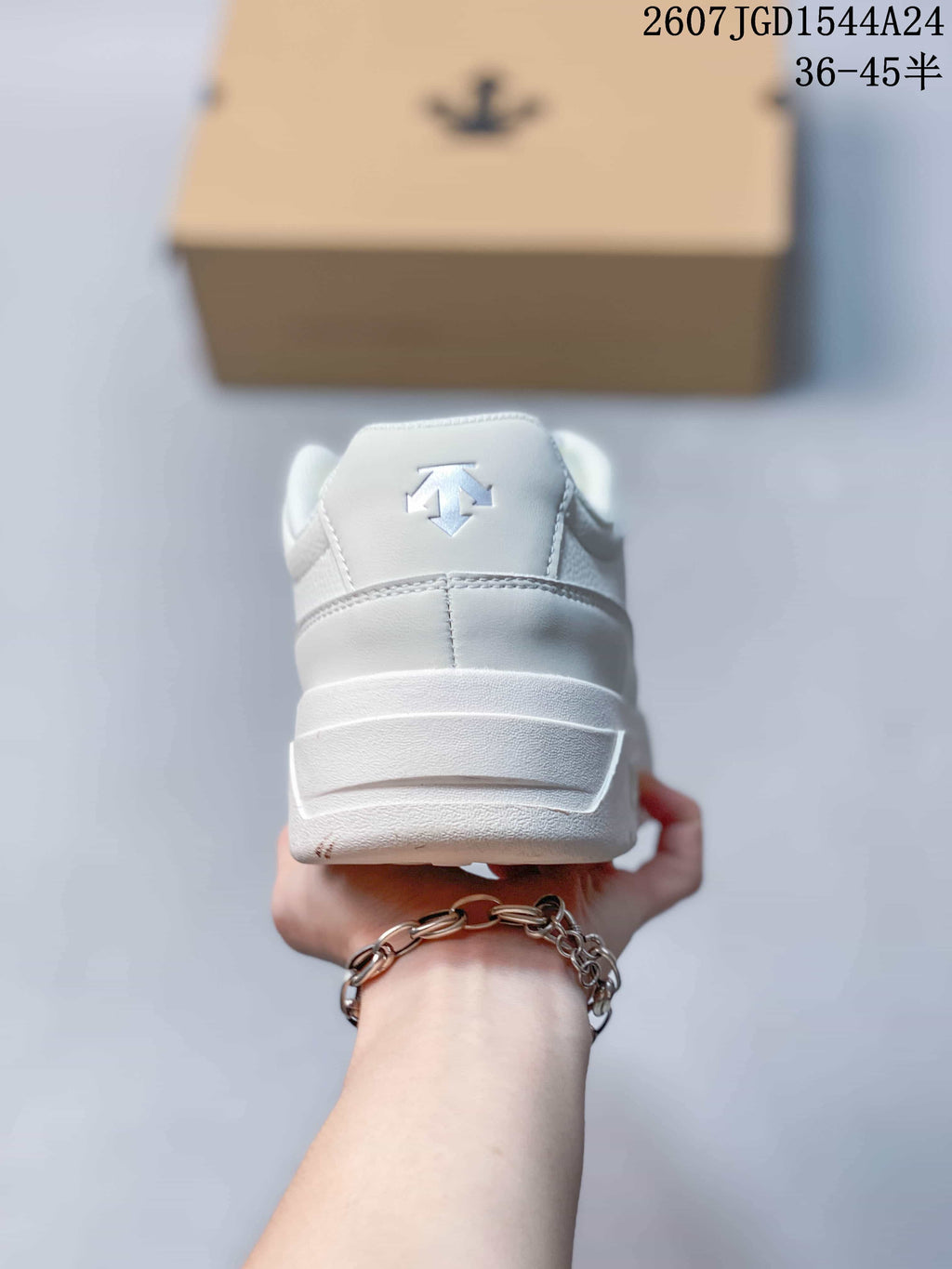 Rear view of the white sneaker showing the padded heel and raised logo detail.