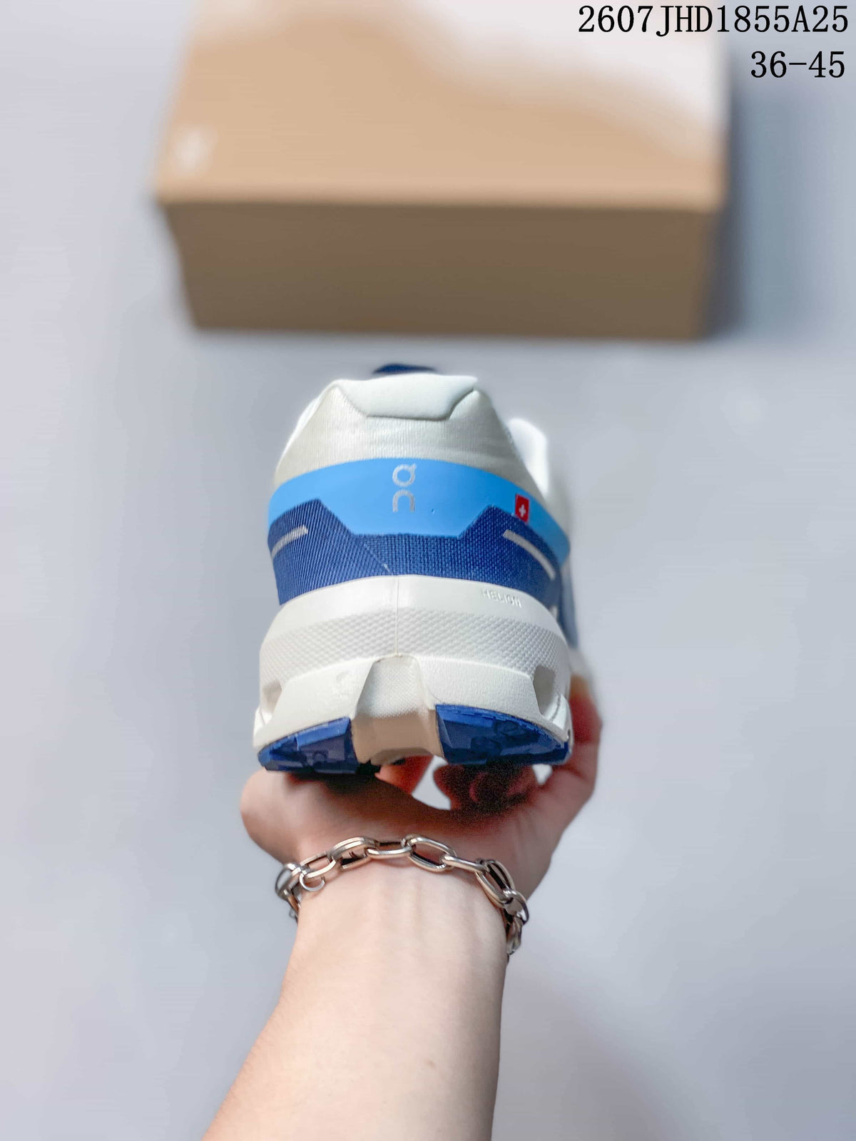 Rear view of the white and blue sneaker showing the padded heel collar, layered heel details, and segmented outsole.