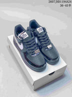 Pair of black and white low-top sneakers shown on a white shoebox, with contrasting Swoosh panels and lace details.