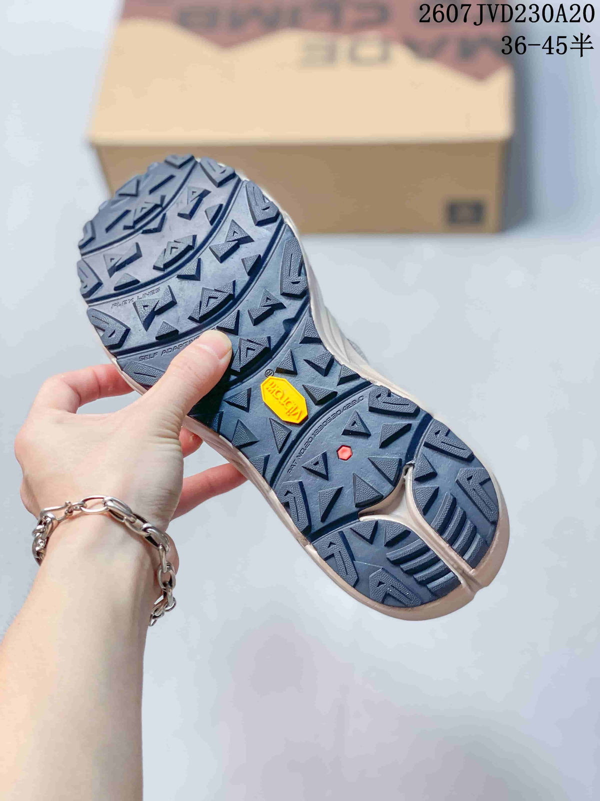 Close view of the rugged outsole with triangular lugs, Vibram branding, and a red accent detail.