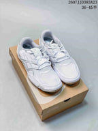 White ASICS low-top sneakers displayed on an ASICS-branded shoe box.