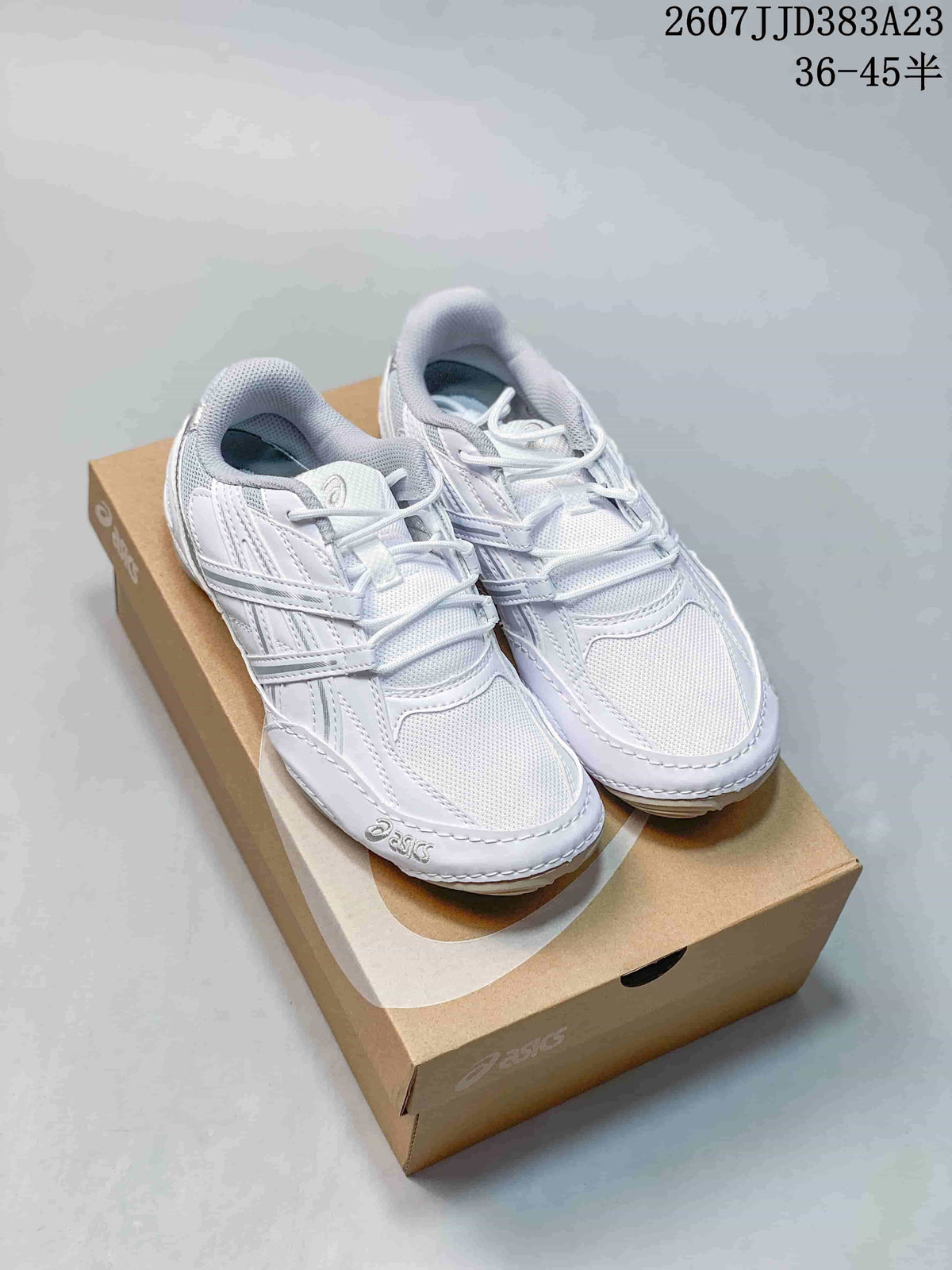 White ASICS low-top sneakers displayed on an ASICS-branded shoe box.