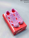 Pair of pink and red Nike Classic Cortez sneakers displayed on a red Nike shoebox.