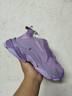 Side view of a purple Balenciaga sneaker with visible Balenciaga branding, mesh detailing, and a textured chunky outsole.