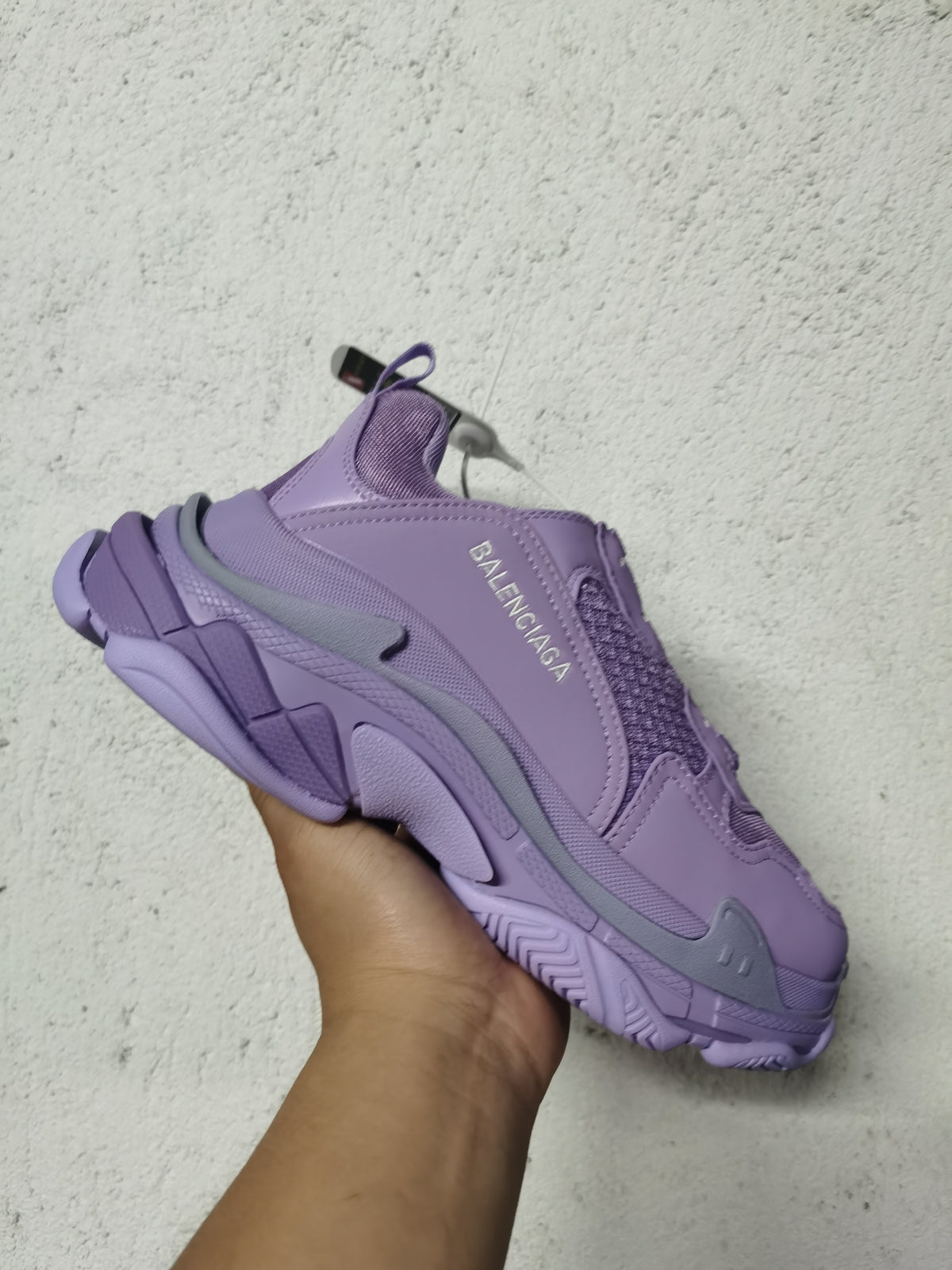 Side view of a purple Balenciaga sneaker with visible Balenciaga branding, mesh detailing, and a textured chunky outsole.