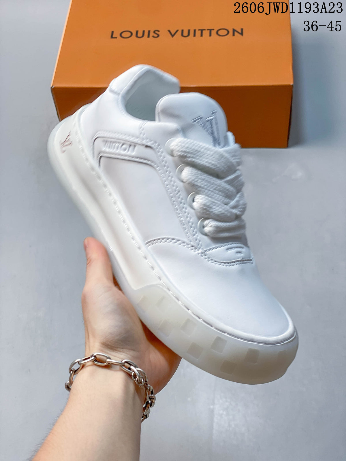 Angled view of a white low-top sneaker with stitched overlays and a chunky sole