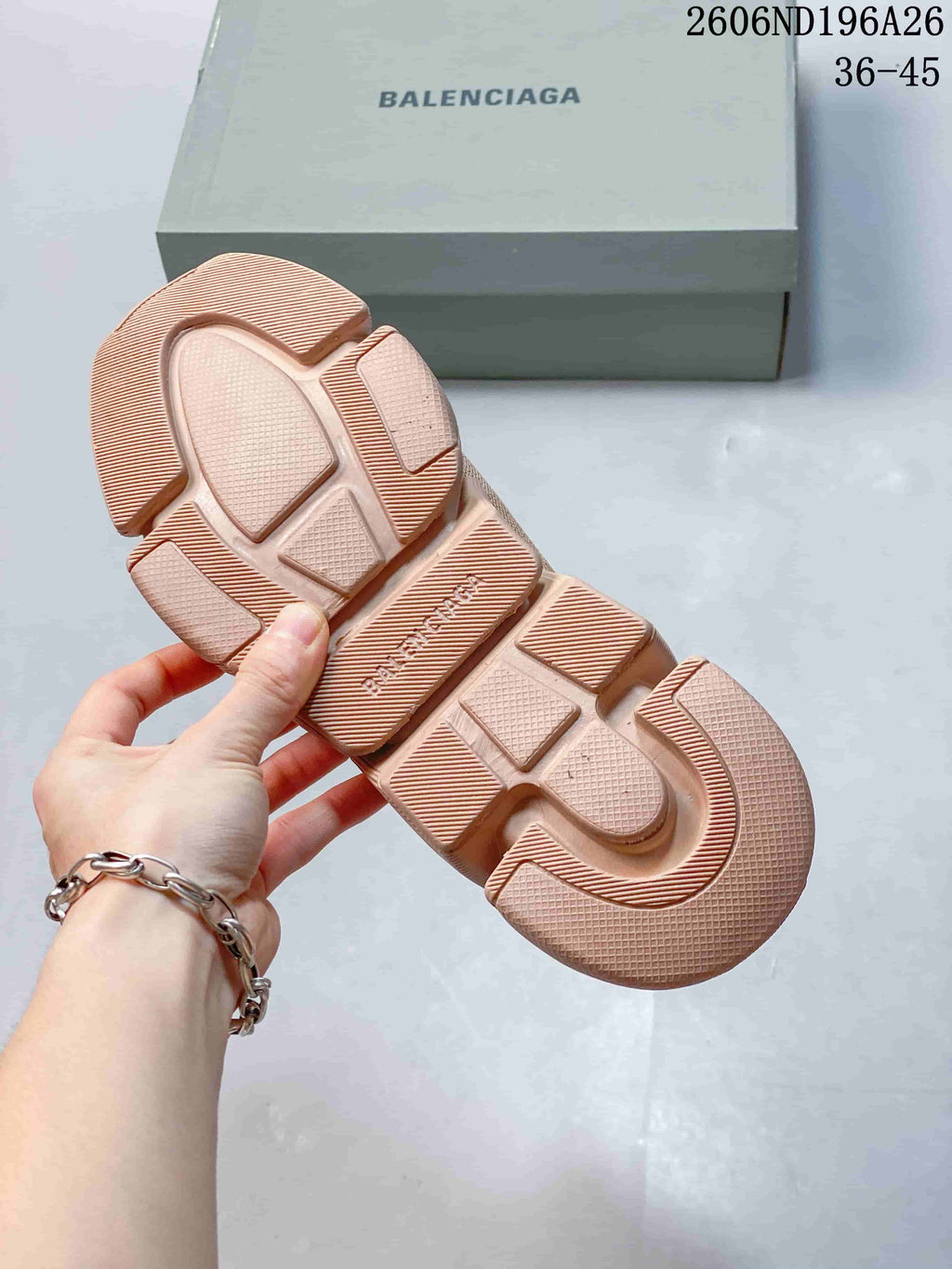 Underside of a beige sneaker showing the segmented tonal outsole and Balenciaga-branded midfoot section.