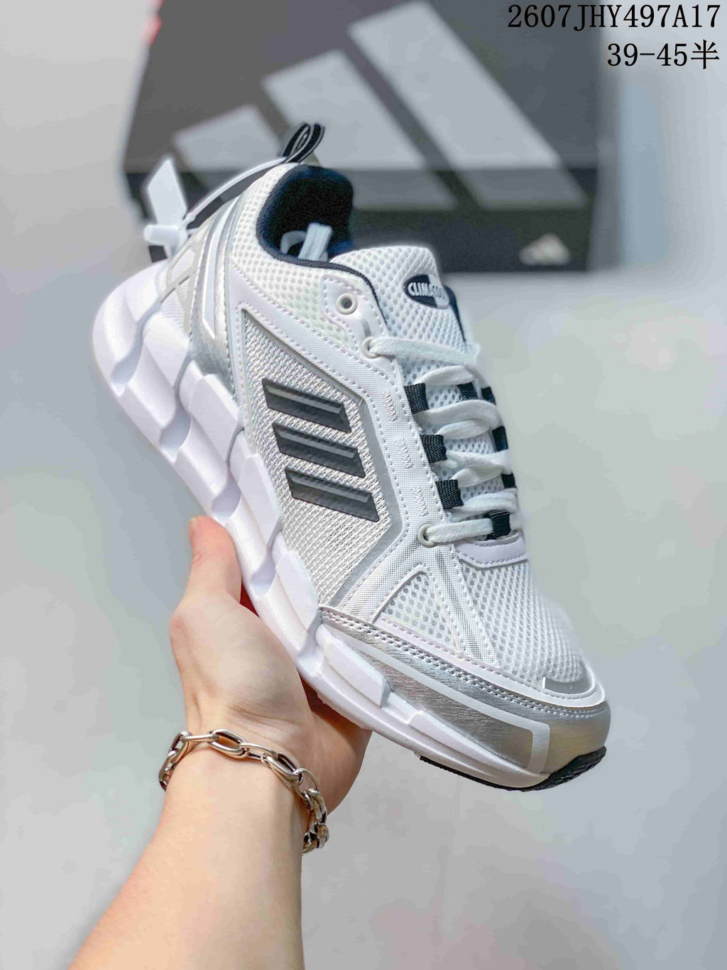 Angled side view of the white Adidas Climacool sneaker showing black side stripes, silver accents and structured panels; image text shows style code 2607JHY497A17 and size range 39–45.