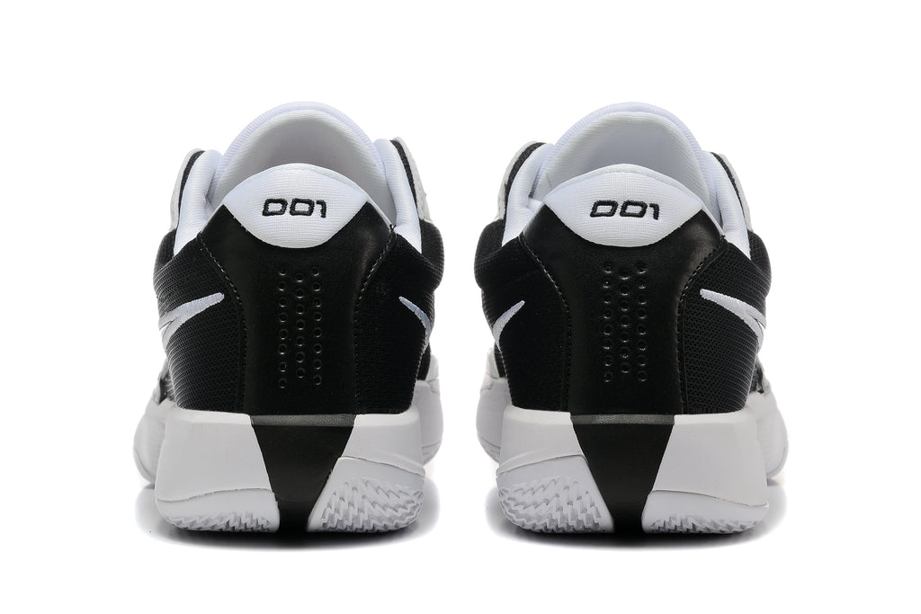 Rear view of black and white Nike G.T. Cut Academy shoes.