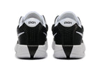 Rear view of black and white Nike G.T. Cut Academy shoes.