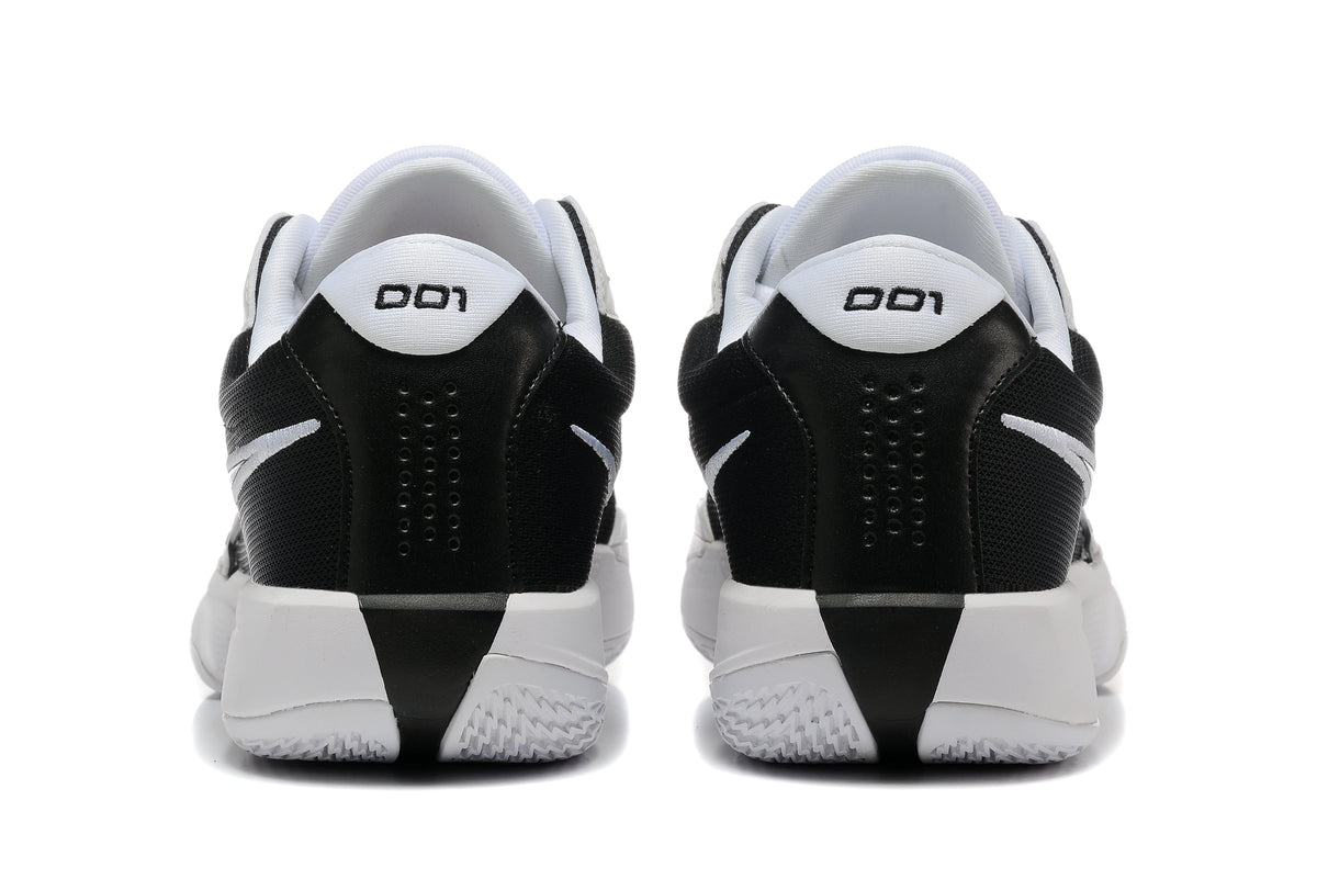 Rear view of black and white Nike G.T. Cut Academy shoes.