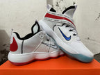 Pair of white Nike sneakers with red heel details, printed straps, and colored translucent outsoles.
