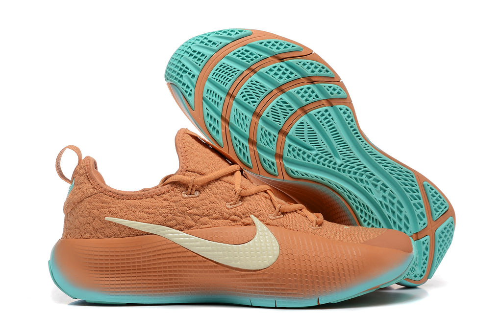 Warm orange LeBron TR1 shoes showing the teal outsole tread
