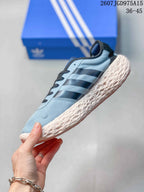 Side profile of the light blue sneaker with black stripes, dark laces, and a textured cream-colored midsole.