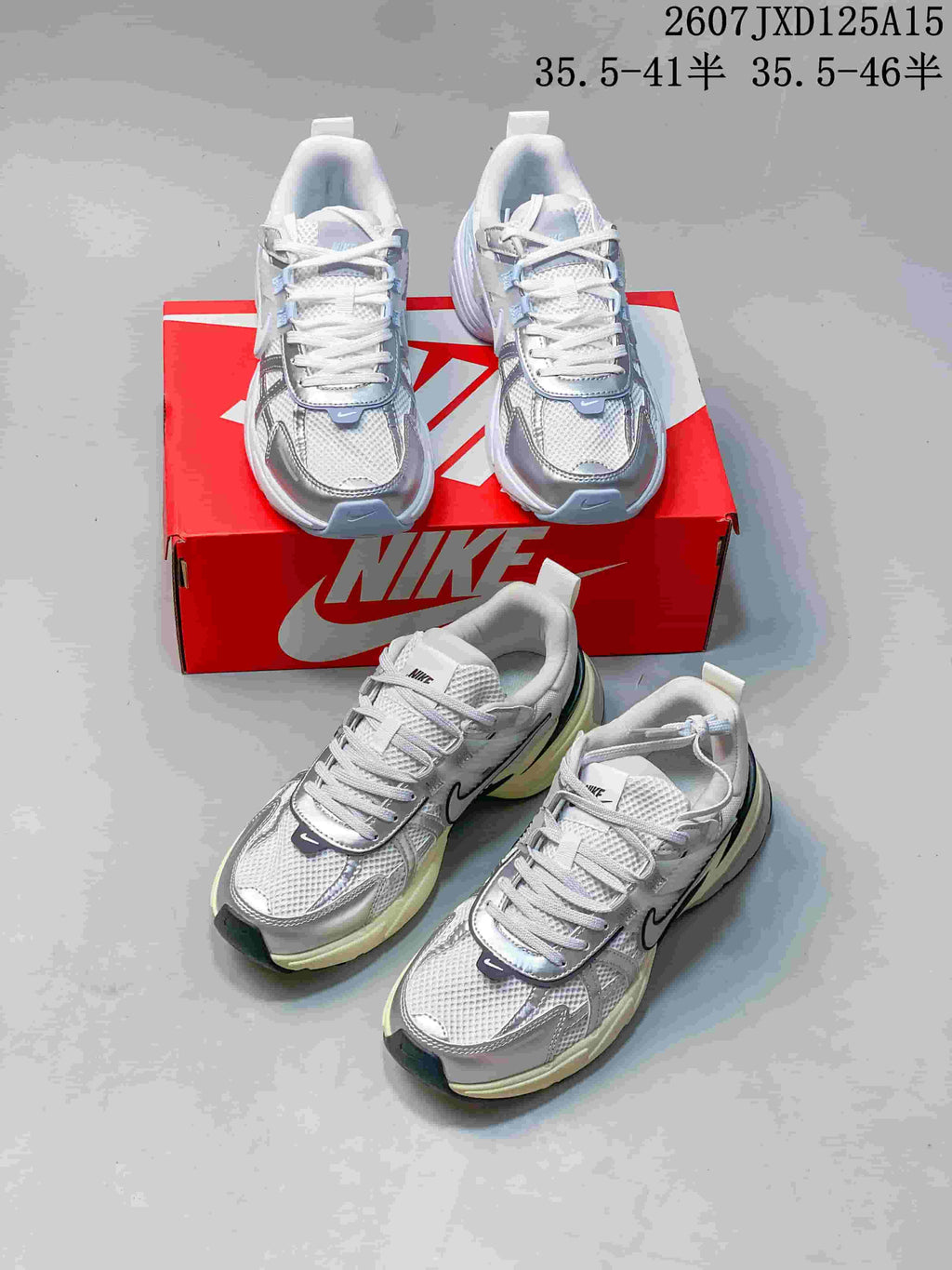Multiple views of silver and white Nike V2K sneakers arranged around a red Nike shoebox.