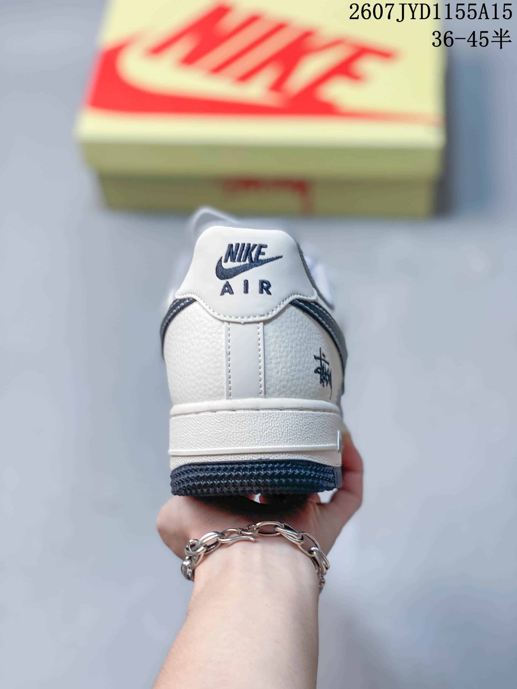 Rear view of a Nike Air Force 1 sneaker showing the white heel, AIR branding, rear graphic detail and dark outsole.