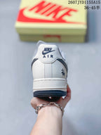 Rear view of a Nike Air Force 1 sneaker showing the white heel, AIR branding, rear graphic detail and dark outsole.
