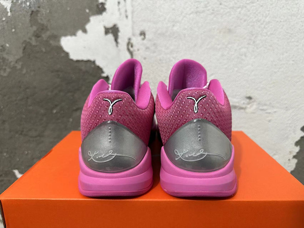 Rear view of pink Nike basketball shoes showing patterned heel panels, gray heel details, and pink midsoles.