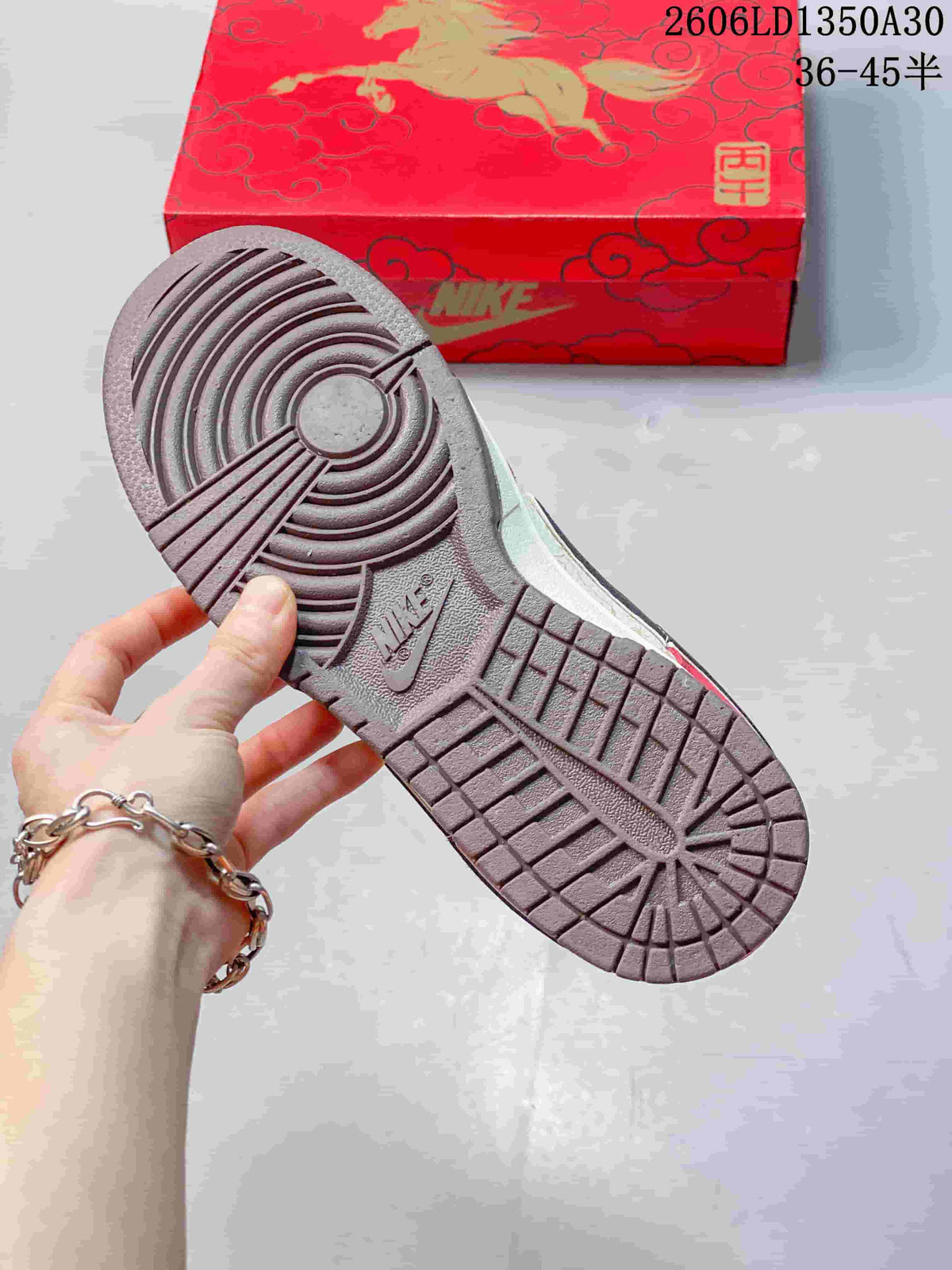 Nike SB Dunk Low outsole with circular tread, shown beside a patterned red shoe box
