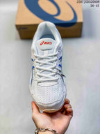 Top view of a white and blue ASICS sneaker showing the mesh toe box, white laces, and padded tongue.