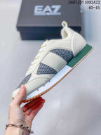 Side view of an off-white EA7 sneaker with gray mesh panels, green heel and midsole accents, and a textured outsole edge.