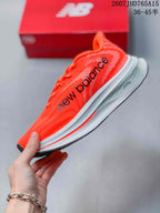 Side profile highlighting the bright orange upper, black branding, and layered white midsole.