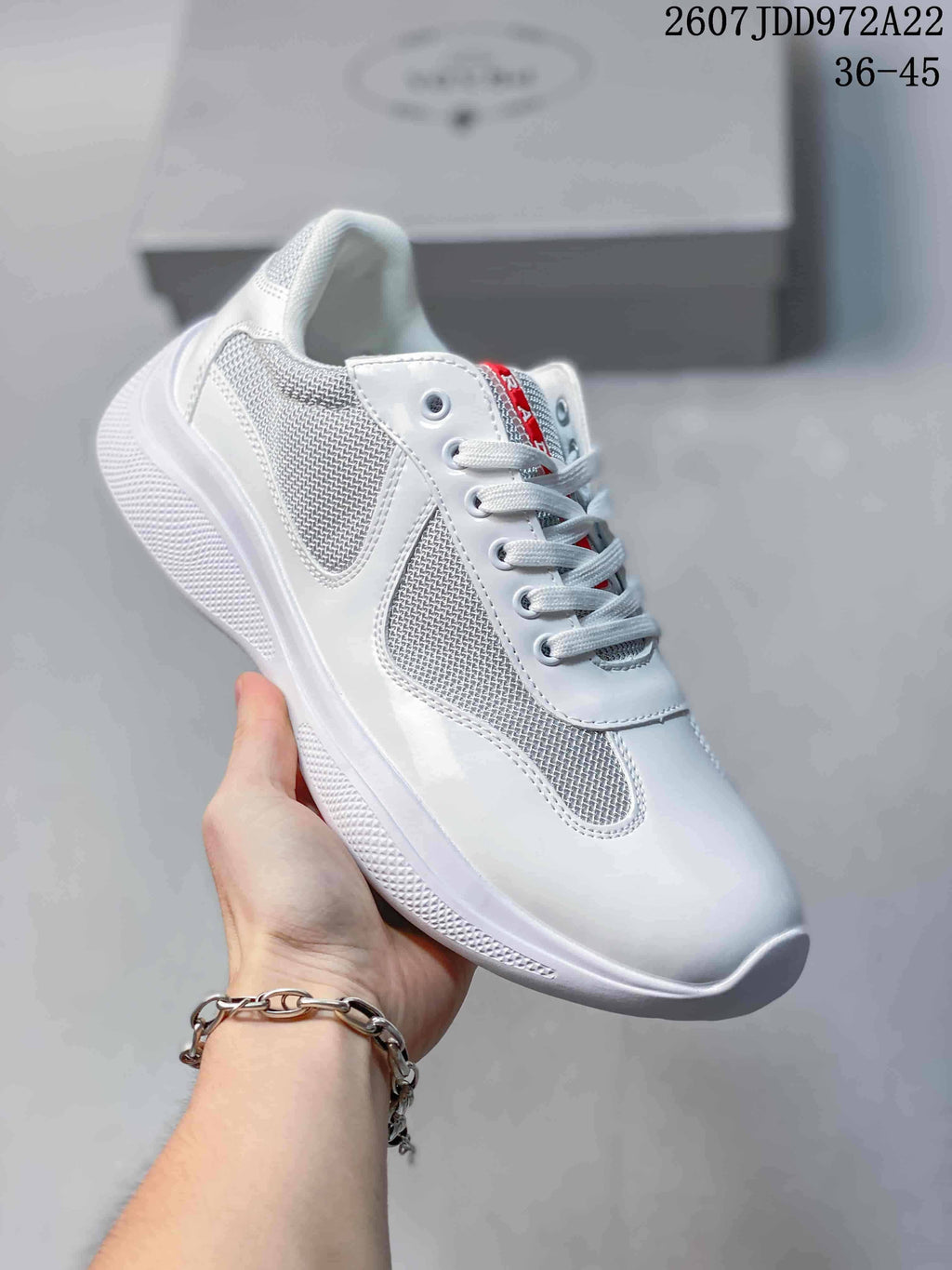 White Prada America's Cup low-top sneaker with textured light panels and white sole.