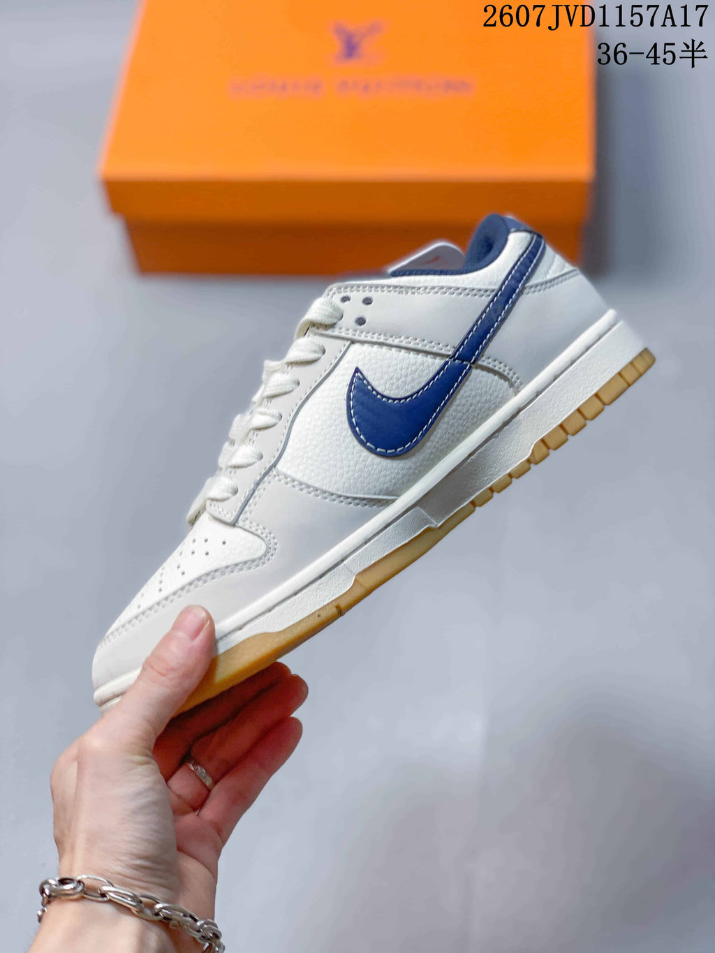 Side view of the white low-top sneaker with a navy Swoosh, white midsole, and gum outsole.
