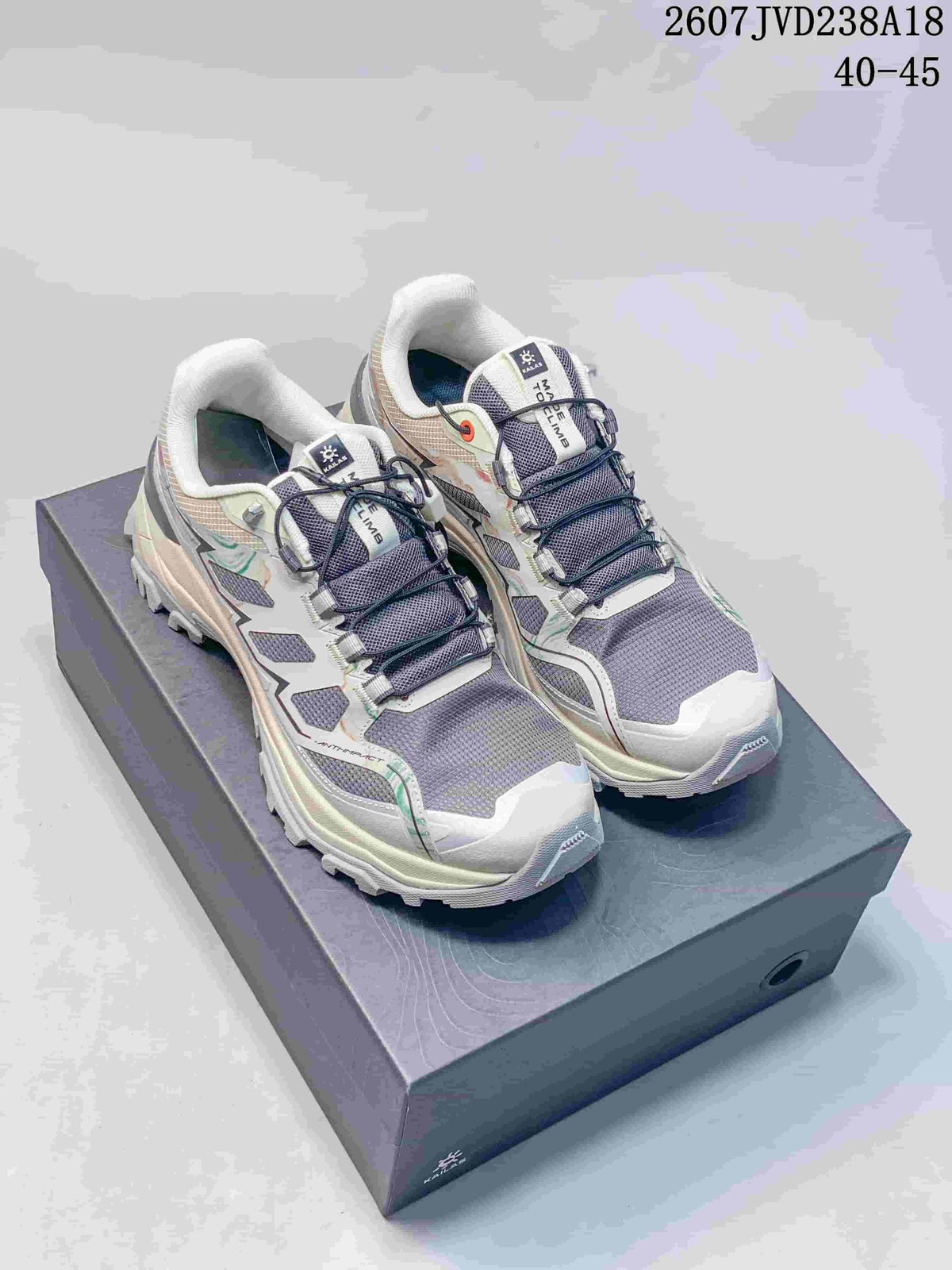 Pair of light gray and white KAILAS hiking shoes with dark laces and green accent details displayed on a shoebox.