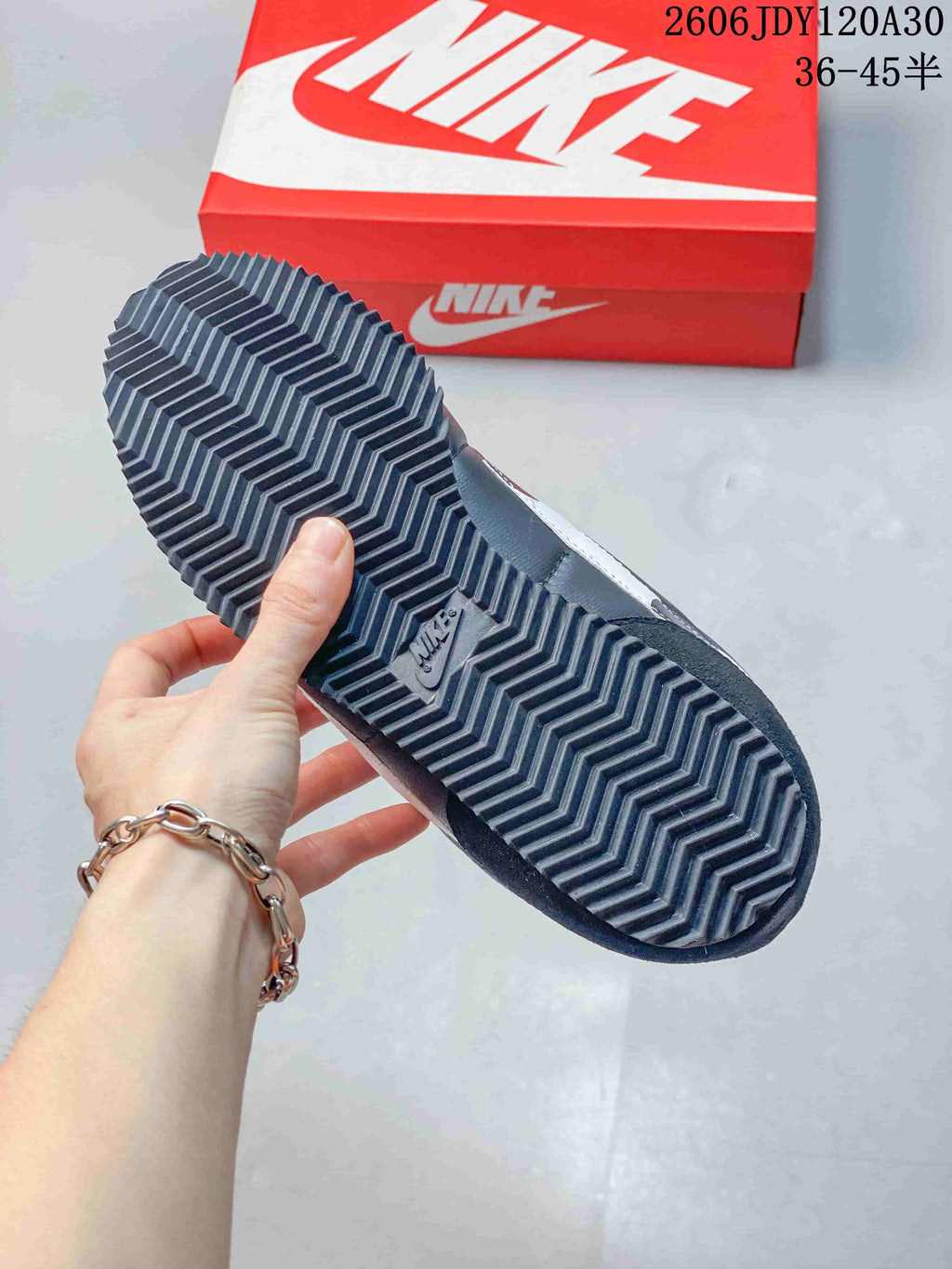 Close-up of the ridged outsole on a dark Nike Classic Cortez sneaker