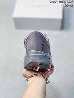 Rear view of the gray sneaker showing the padded heel, On logo, sculpted sole, and heel outsole details.
