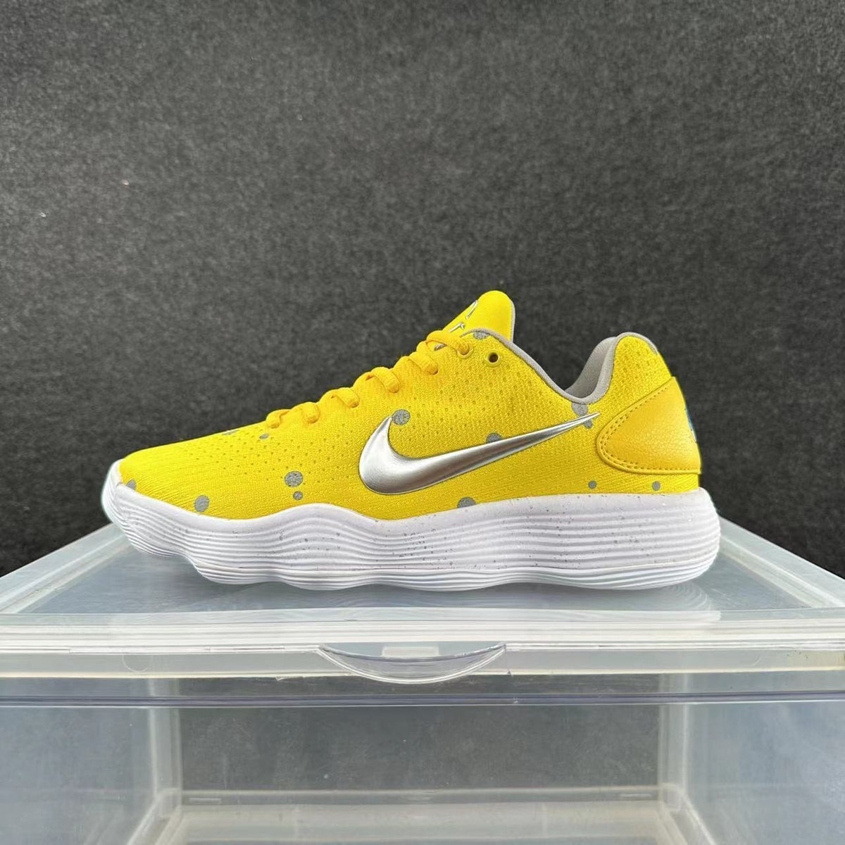 Side view of a yellow lace-up sneaker with a silver Swoosh, gray accents, and a white textured sole.
