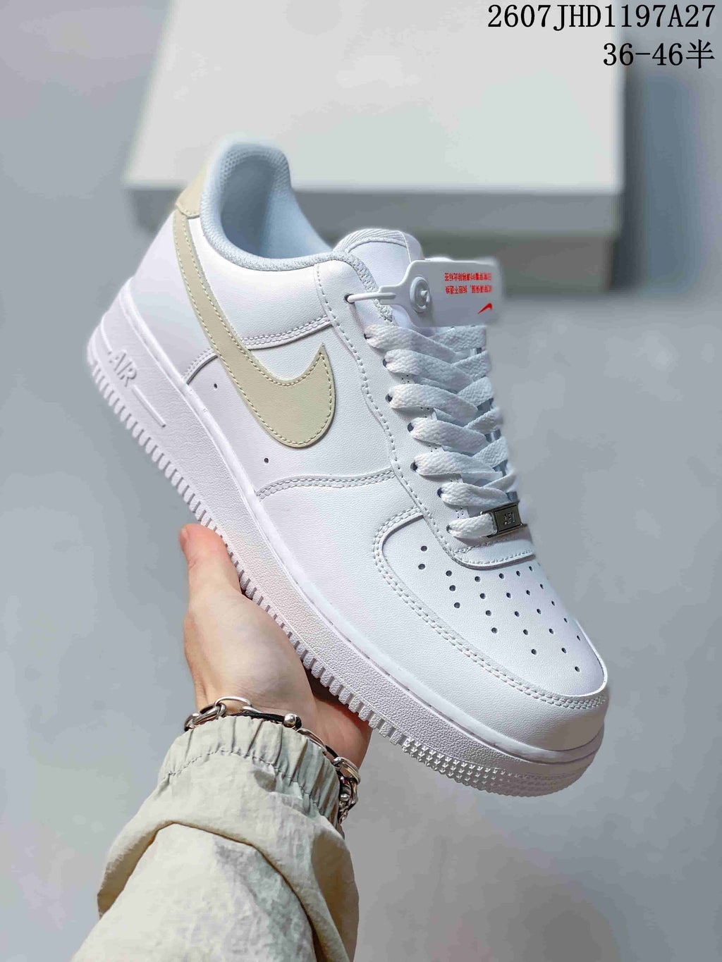 Angled side view of the white low-top sneaker with pale beige Swoosh, perforated toe box, Air-branded midsole, and textured outsole.