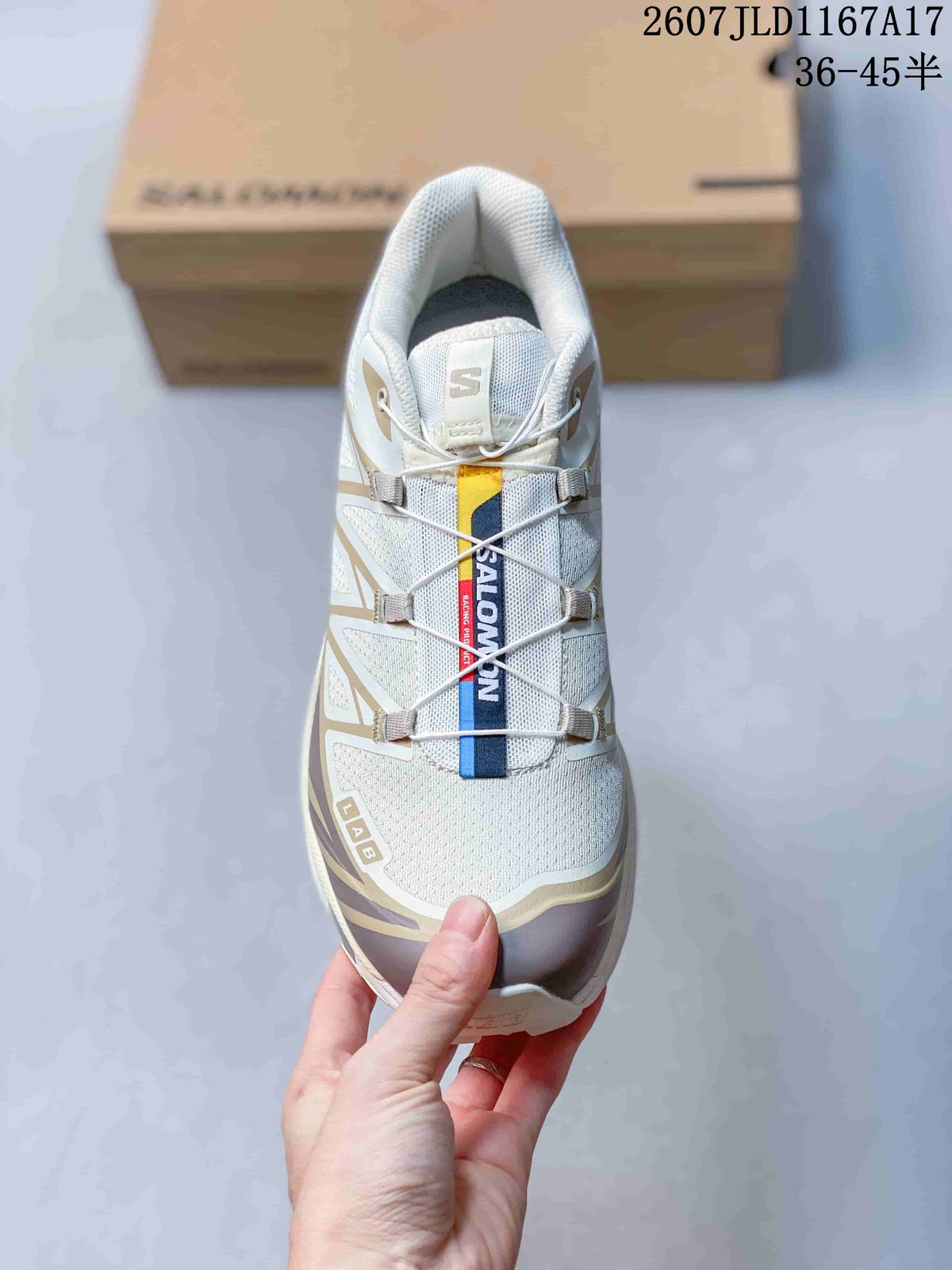 Top view of a Salomon XT-6 showing the textile-style toe box, quick-lace cords, tongue branding, and beige and brown accents.