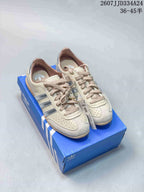 Cream and silver adidas Originals Japan Changle sneakers displayed on a blue shoebox.