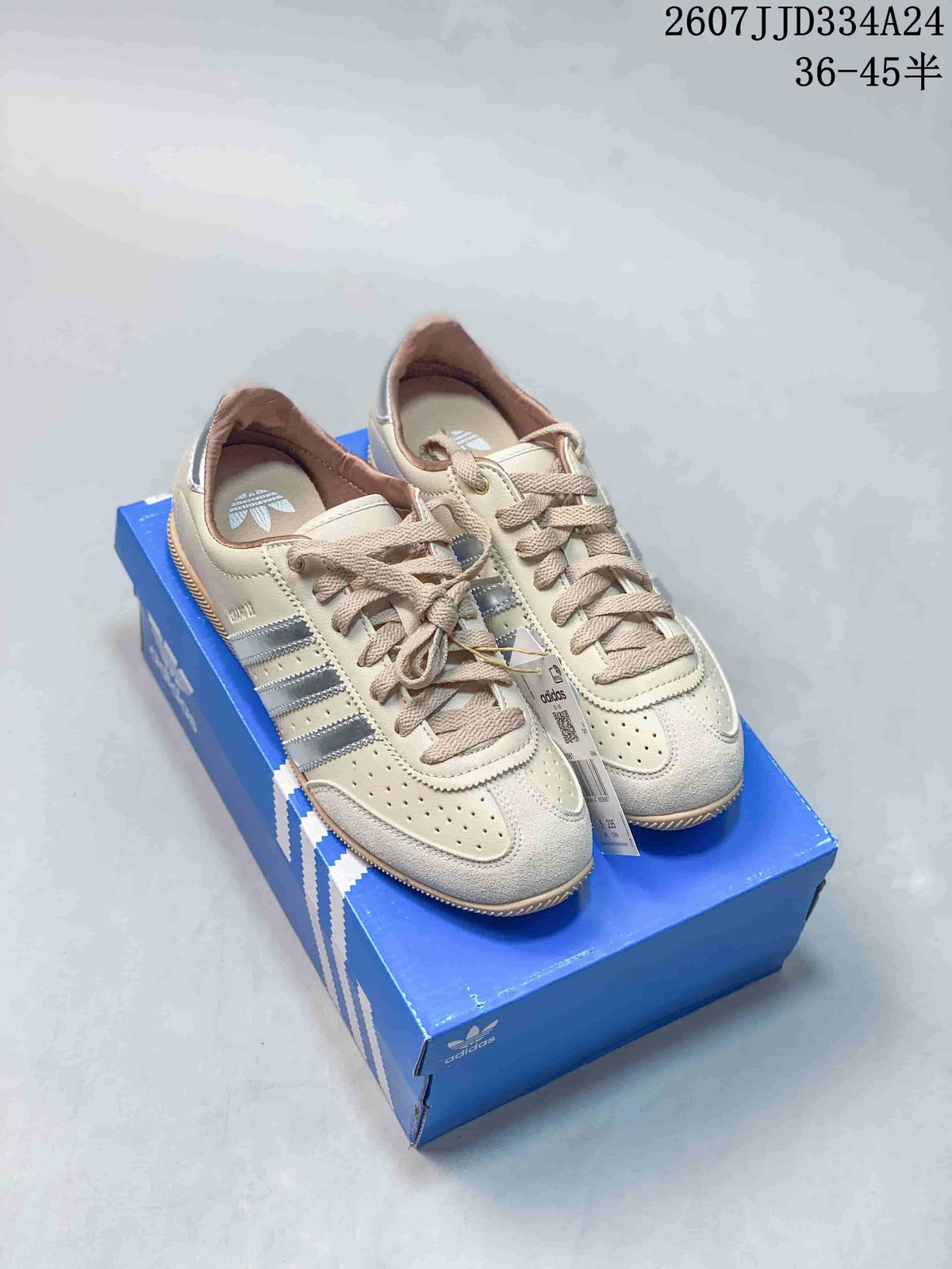 Cream and silver adidas Originals Japan Changle sneakers displayed on a blue shoebox.
