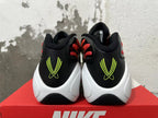Rear view of black Nike basketball shoes with neon yellow heel logos and white sculpted midsoles.