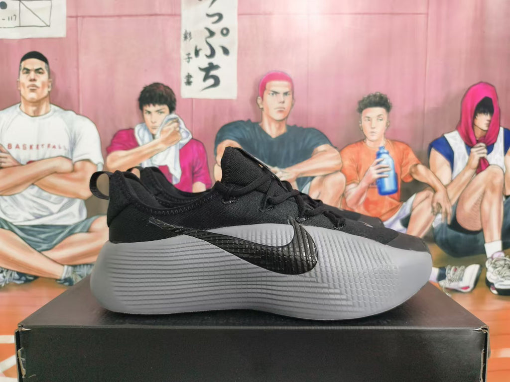 Side view of a black Nike sneaker with a grey textured midsole and contrasting Swoosh
