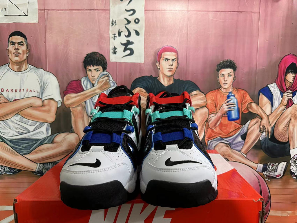 Front view of white and black basketball sneakers with red, teal, and blue accents.
