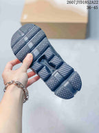Outsole view of a black On sneaker showing the segmented tread pattern and central CloudTec-marked structure.