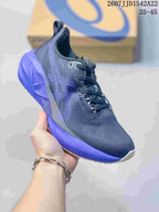 Angled side view showing the dark navy upper, purple midsole and textured outsole edge.