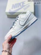 Side view of the white sneaker showing blue-outlined swoosh detailing, blue outsole accents, and textured panel construction.