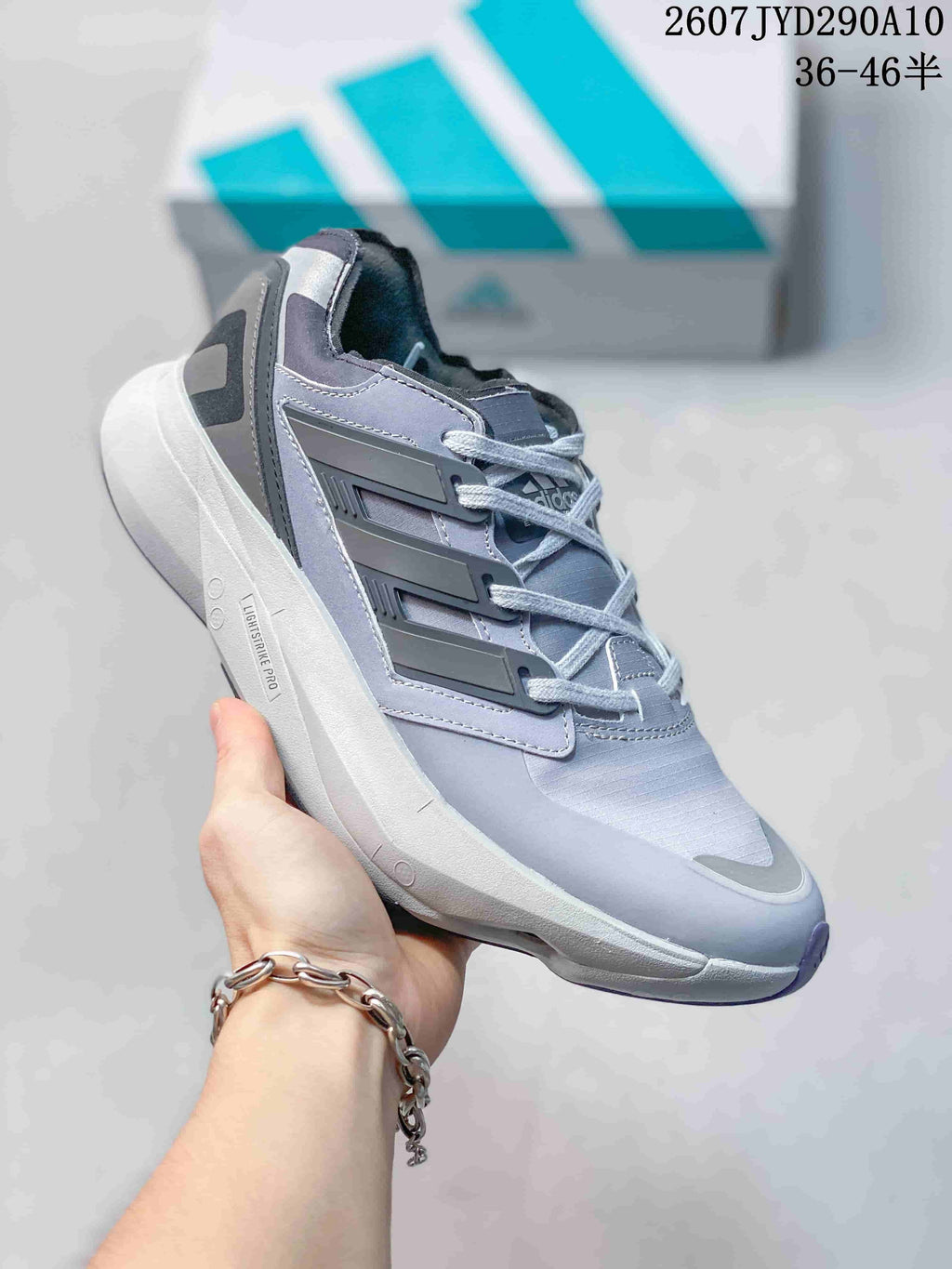 Side view of a gray adidas Equipment Adios Pro sneaker showing the layered side detail and platform-style sole.