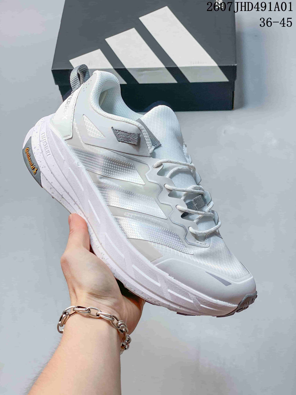 White Adidas Terrex low-top shoe with gray accents and a sculpted sole; image also displays the size range 36–45.