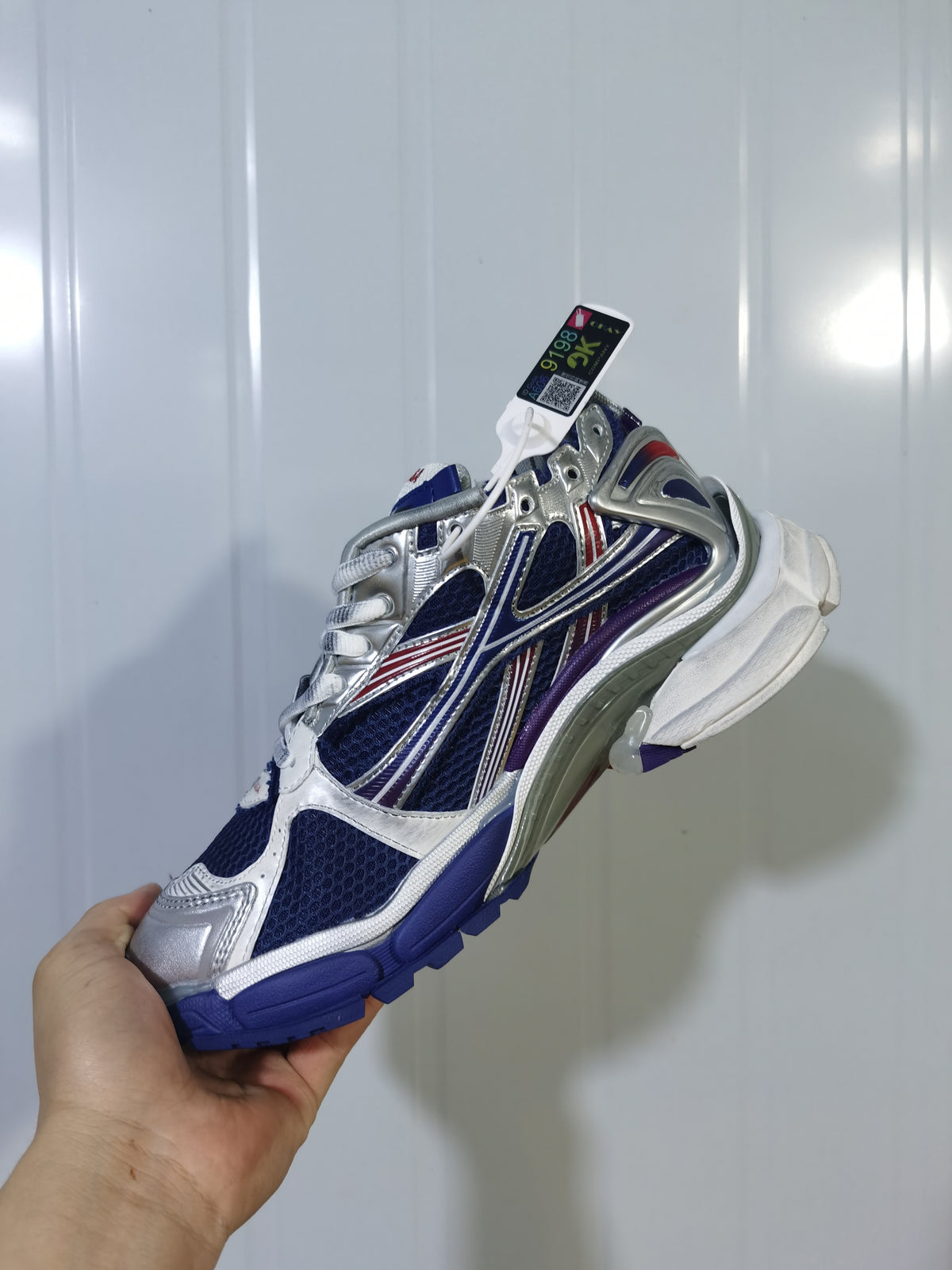 Side view of the Balenciaga Runner sneaker showing the mesh-like panels, contrast overlays, laces and sculpted outsole.
