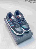 Pair of navy blue adidas Originals Tekkira Cup sneakers with teal and red accents displayed on a shoebox.