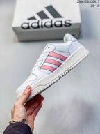 Side profile of the adidas Entrap sneaker with pink stripes, white upper, and layered sole.