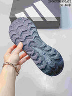 Close-up of the patterned outsole on a gray and blue trail running shoe